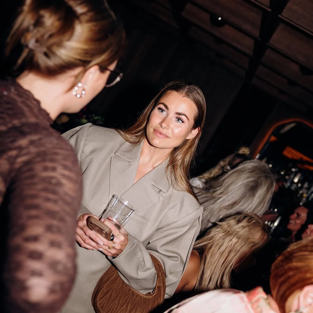 Two guests in conversation during an evening gathering