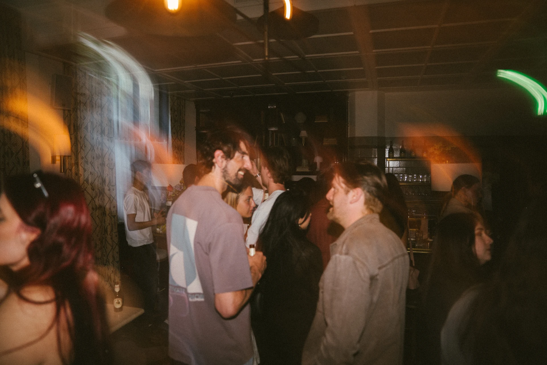Guests mingling in a warmly lit venue with motion blur