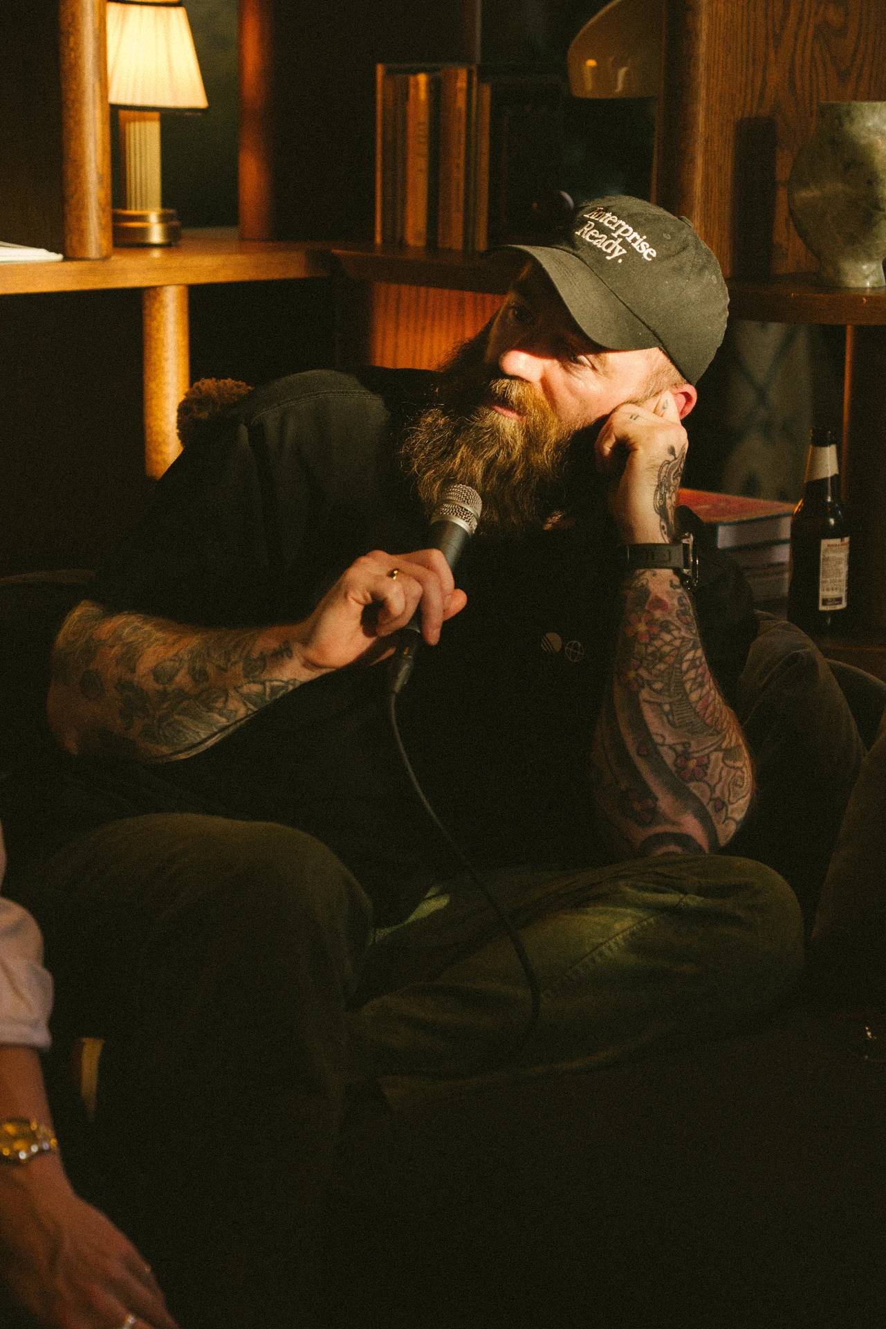 Portrait of a guest wearing a cap in a warmly lit bar