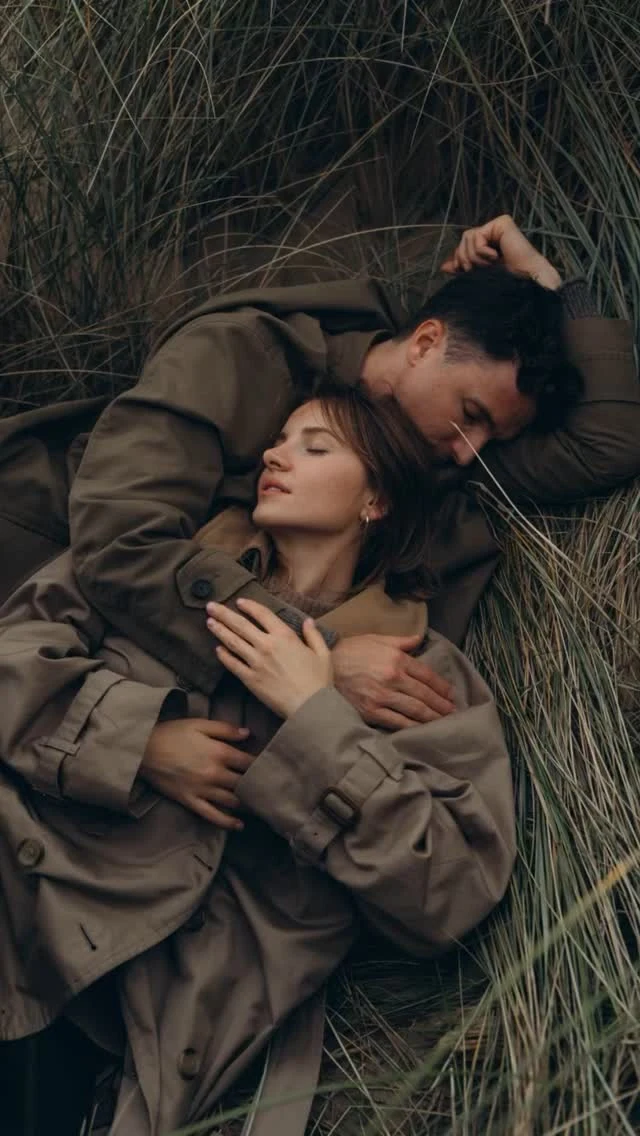 Couple lying together in dune grass