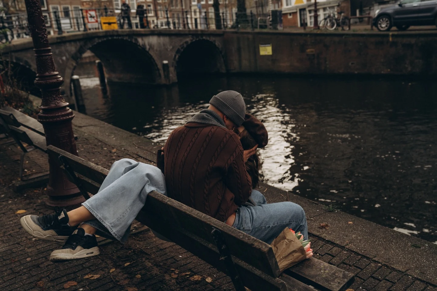 Couple sitting closely on a canal-side bench