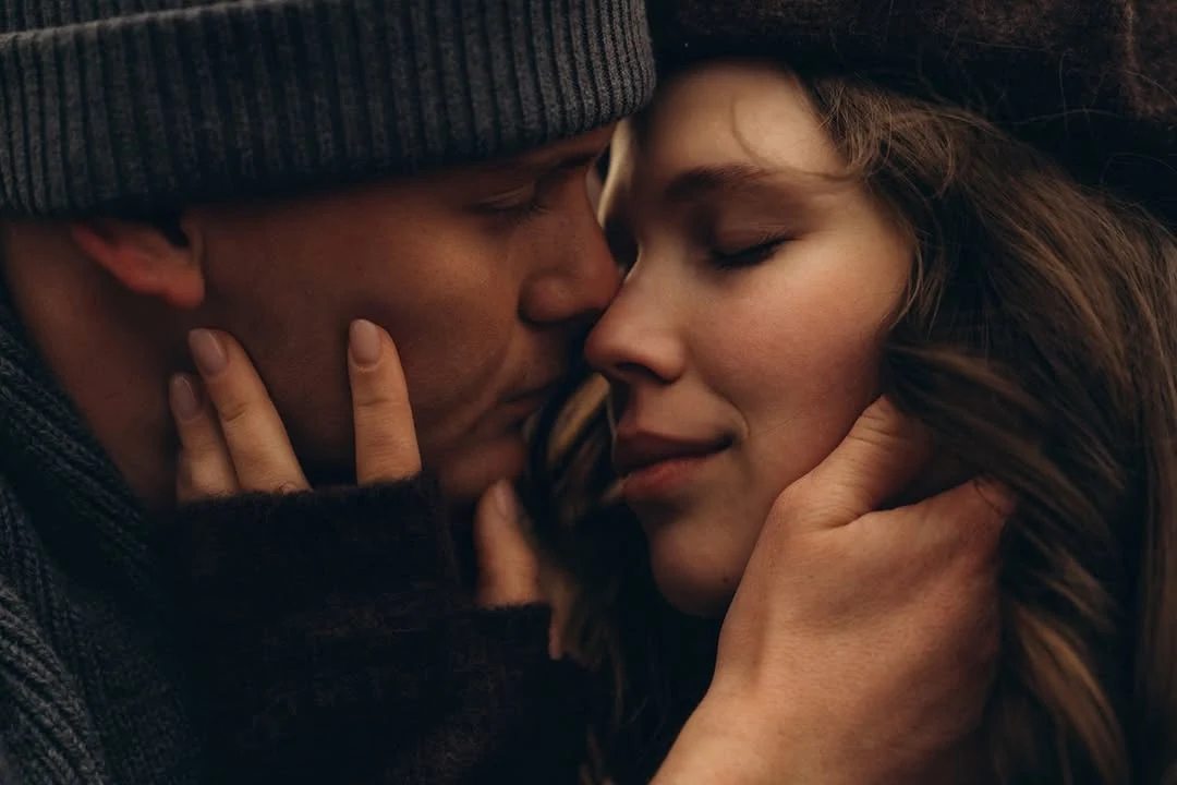 A close, tender moment between two people in winter coats