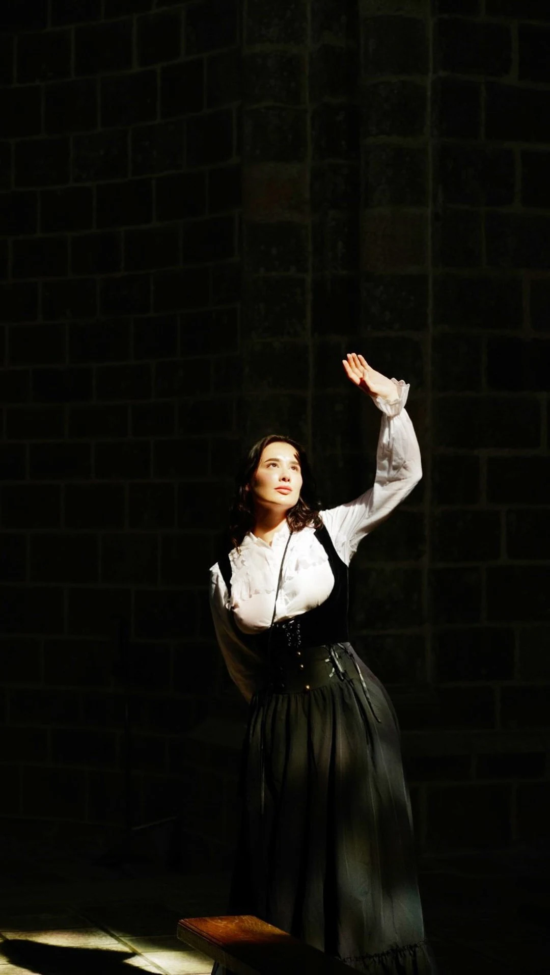 Photographer Viktoriia Loskutova standing in a shaft of light