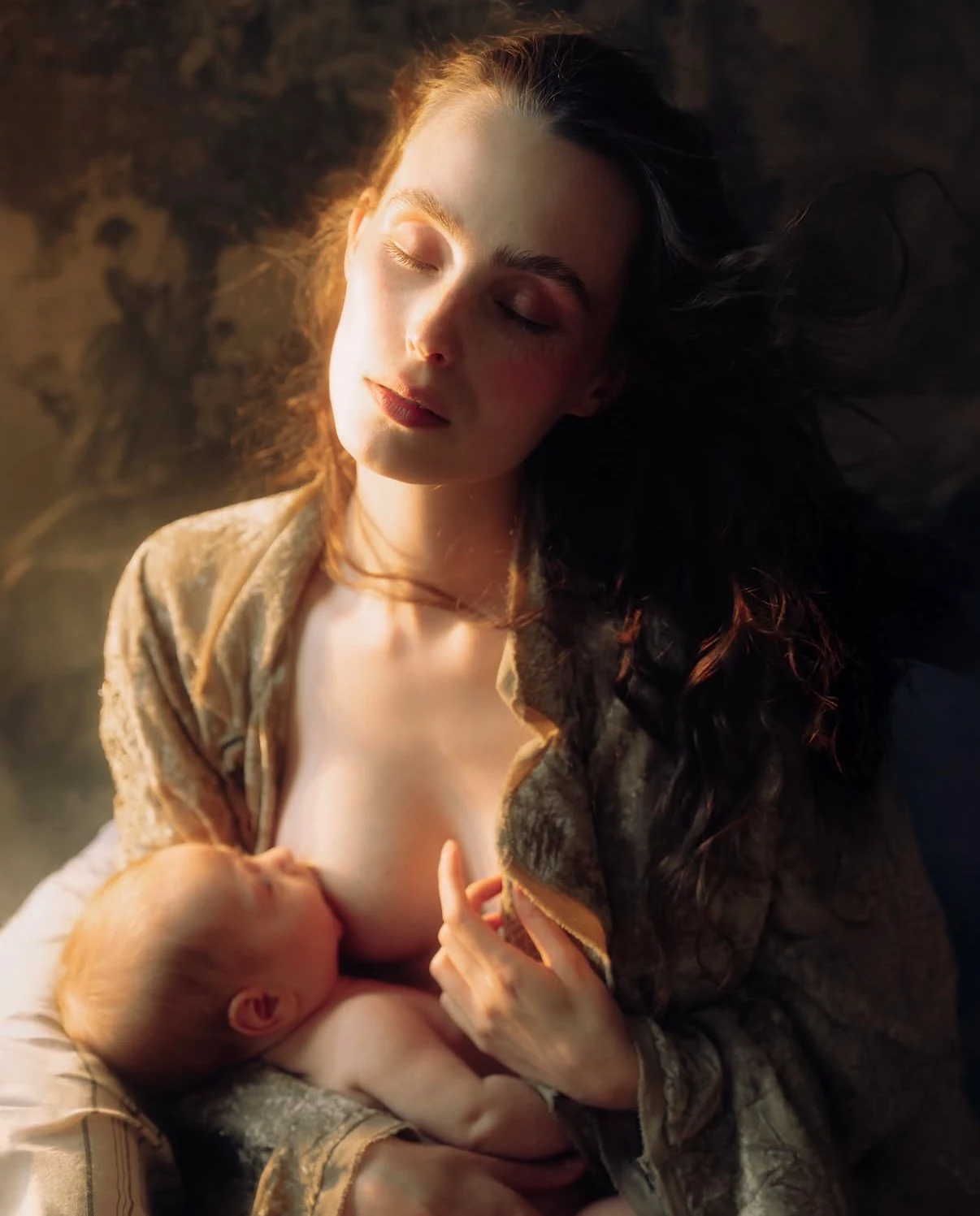 Mother breastfeeding her baby in warm side light