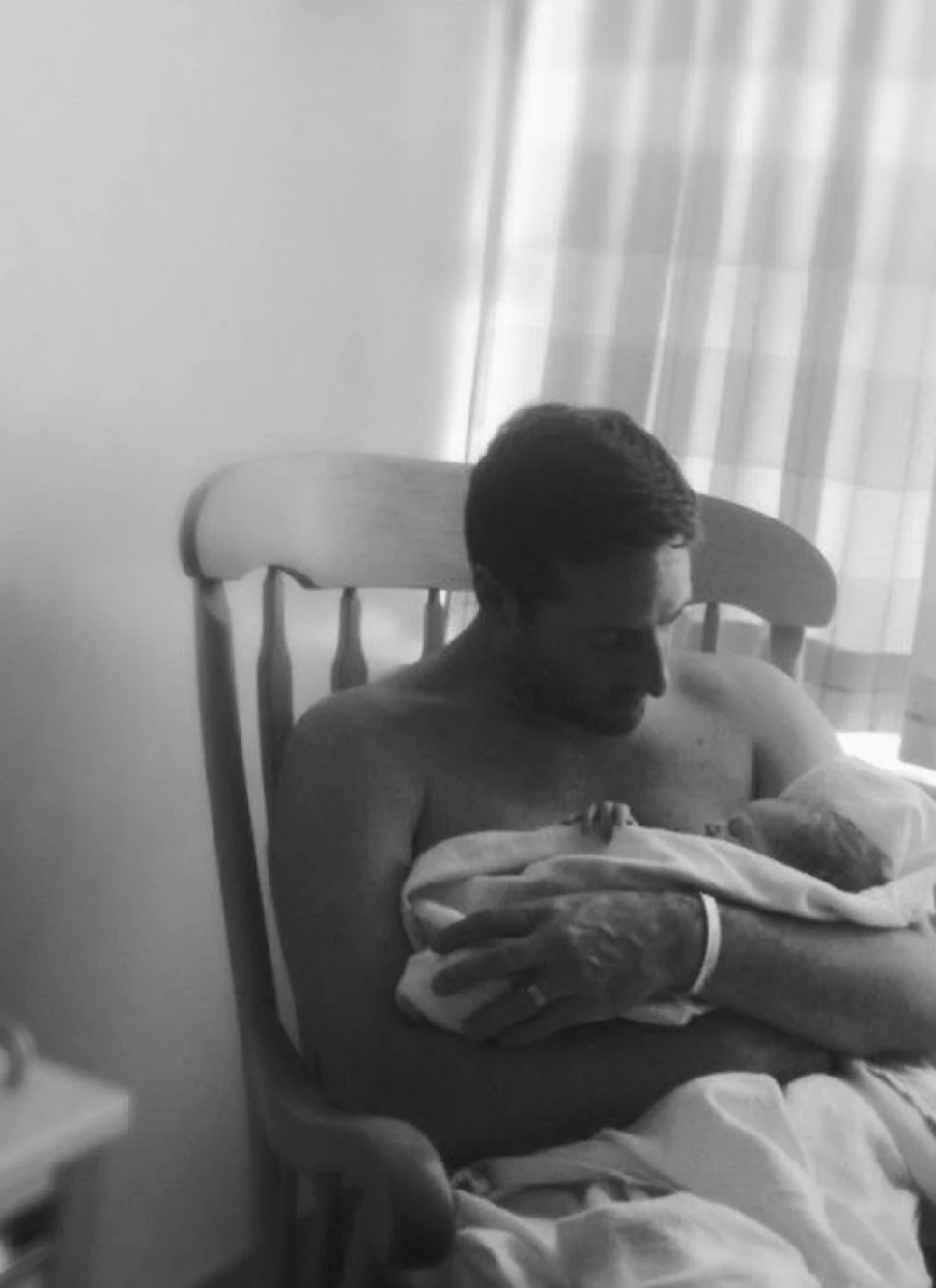 Black-and-white portrait of a father holding his baby