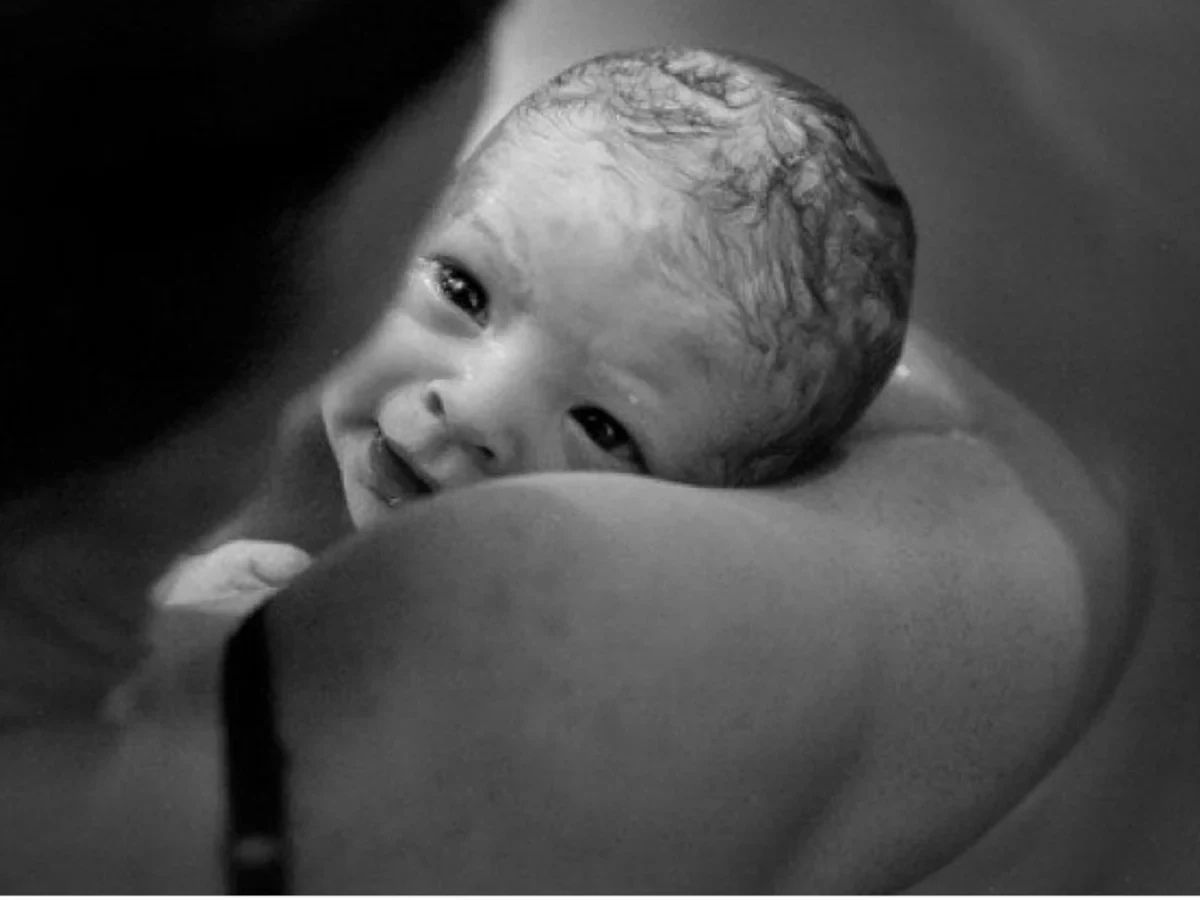 Baby looking out while resting against a parent’s shoulder