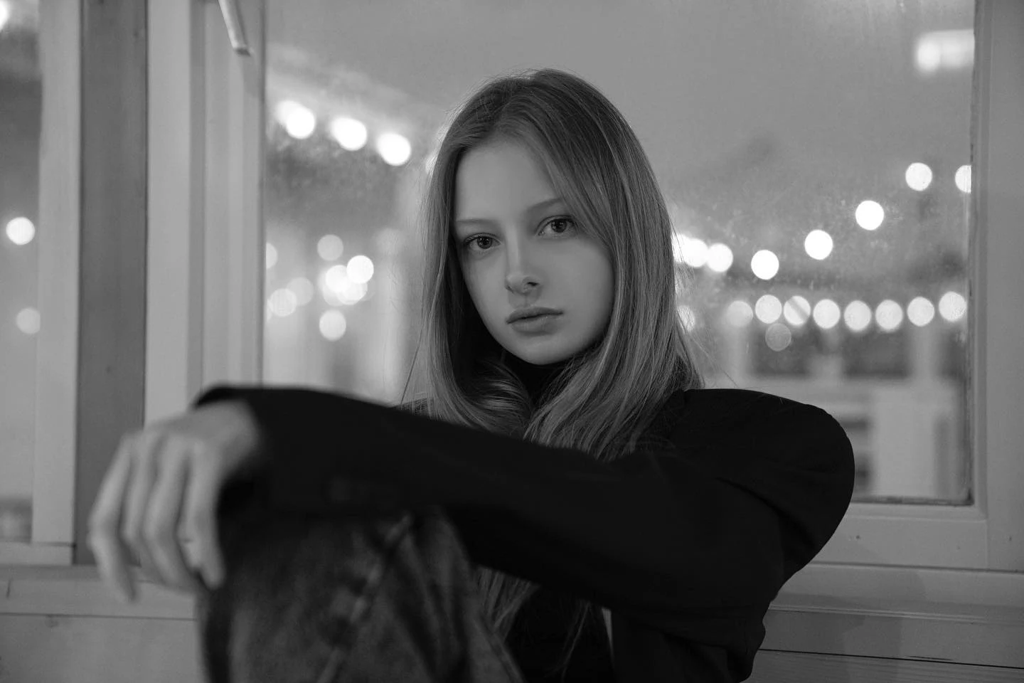 Black-and-white portrait of a woman with soft lights in the background