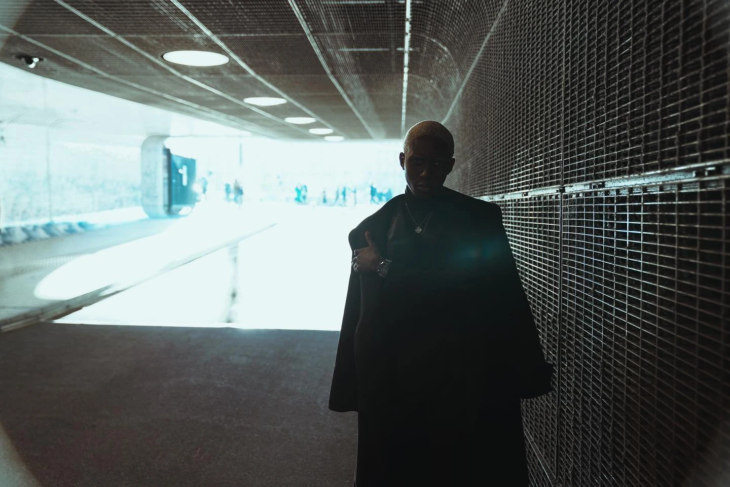 Silhouette of a man in a glowing architectural passage