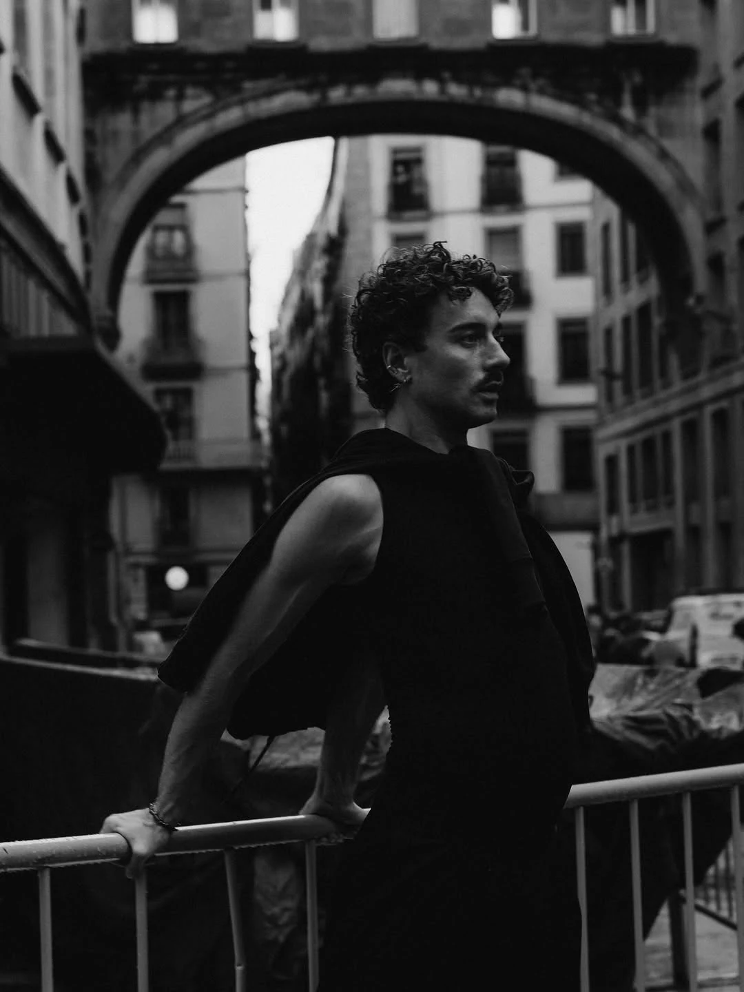 Man in black framed by an ornate city arch