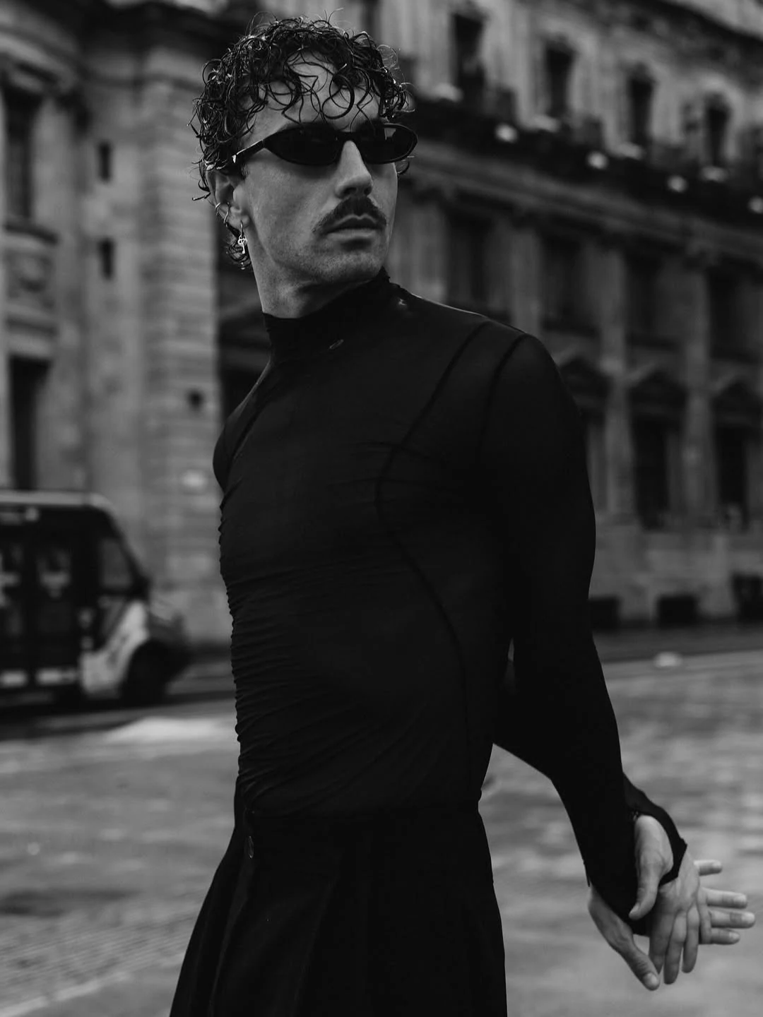 Black-and-white portrait of a man in sunglasses on a city street
