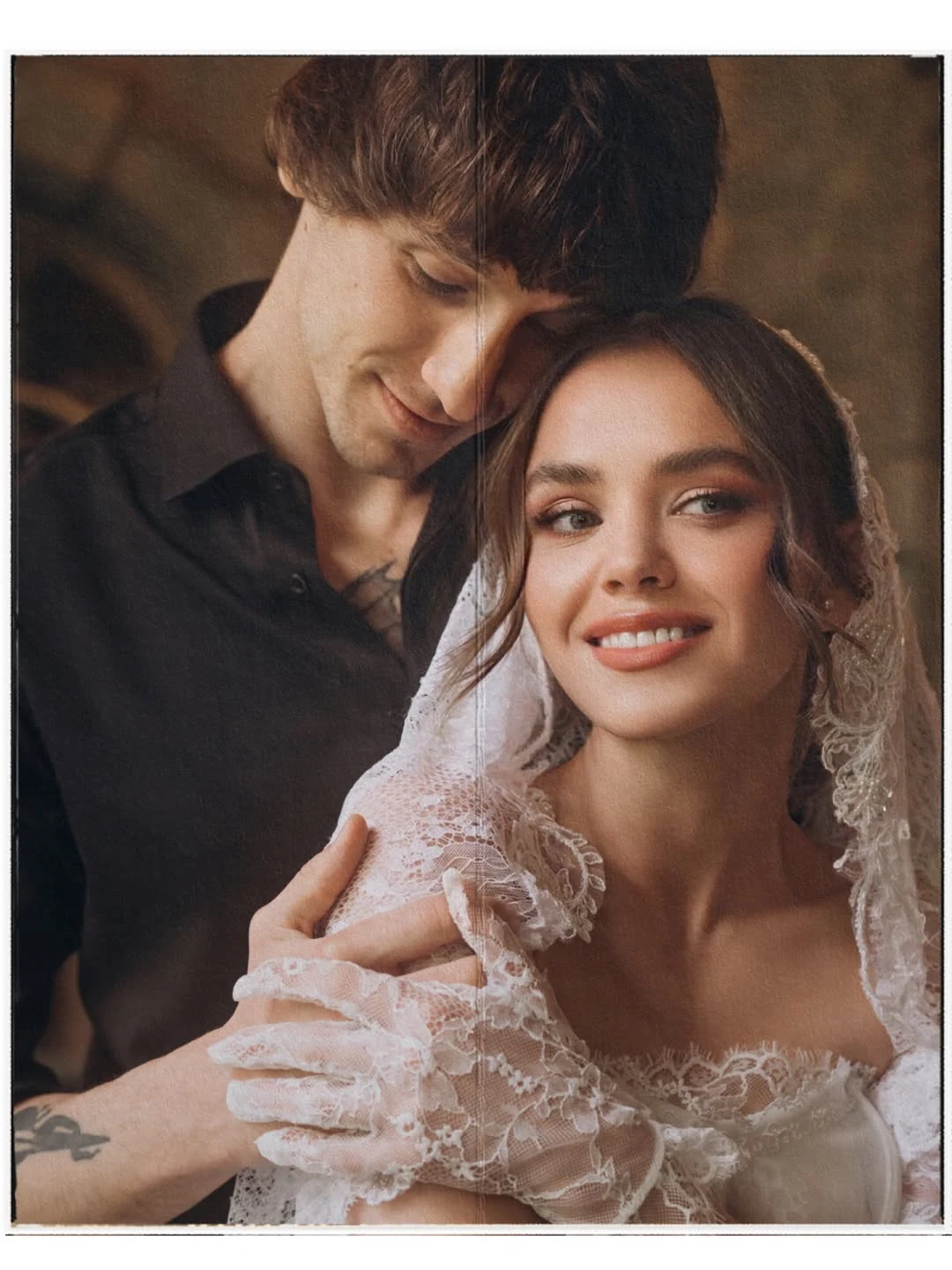 Couple embracing, with the bride smiling towards the camera